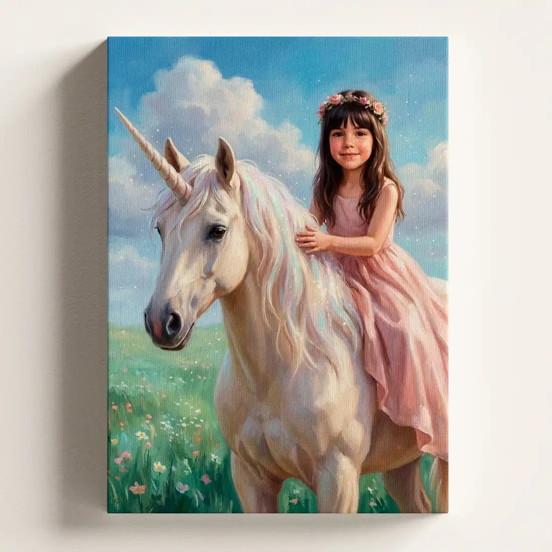 A vertical canvas wall art print depicting a young girl with a pink dress and flower crown riding a white unicorn in a grassy field under a blue sky with clouds.