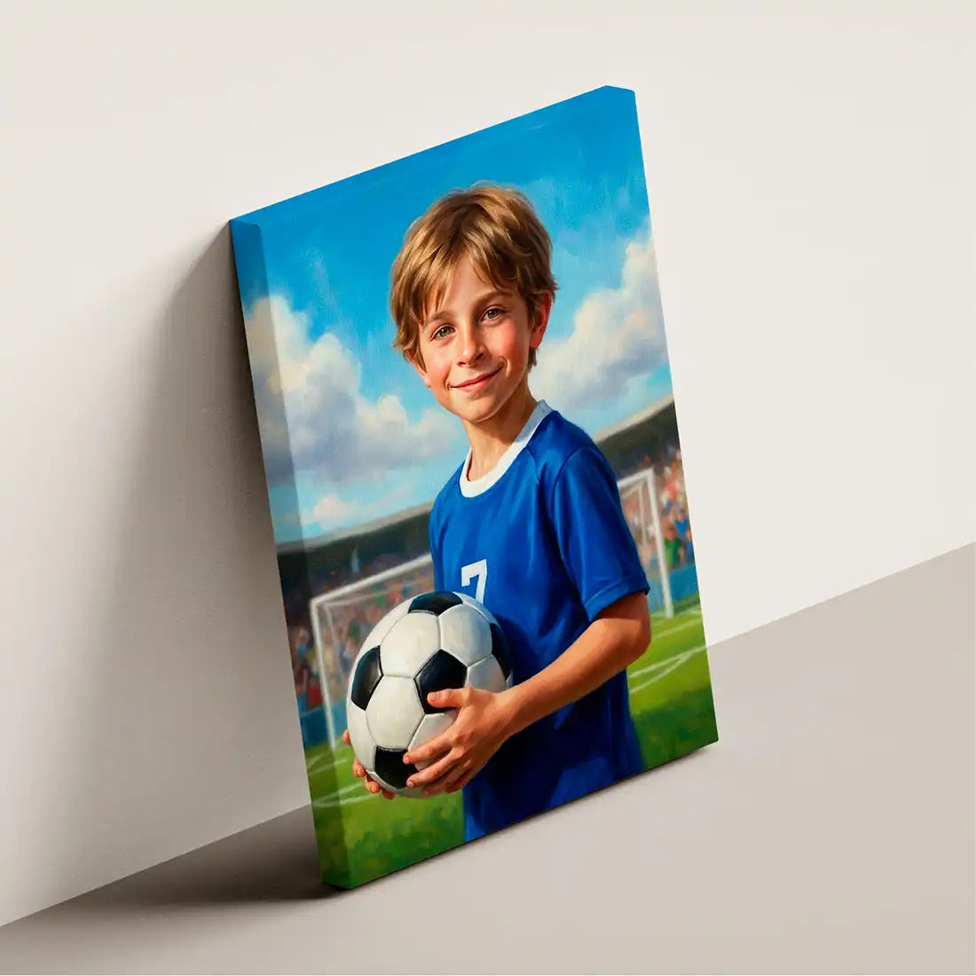 A custom canvas photo print of a young boy soccer player, shown leaning against a white wall. The canvas features a painted portrait of the boy in a blue jersey holding a soccer ball on a green field under a blue sky.