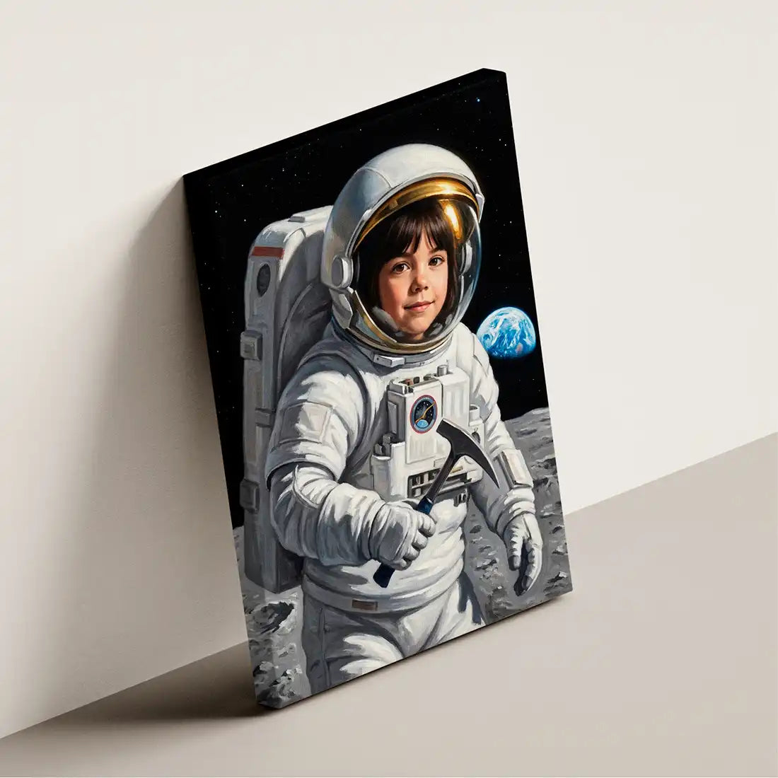 A rectangular canvas print leaning against a light beige wall, showing a painted scene of a child astronaut on the moon with Earth in the background. The artwork fills most of the canvas, and the print itself is the product.